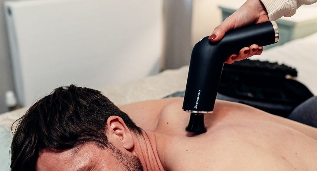 The Use of a Massage Gun to Treat Lower Back Pain While Walking or Standing